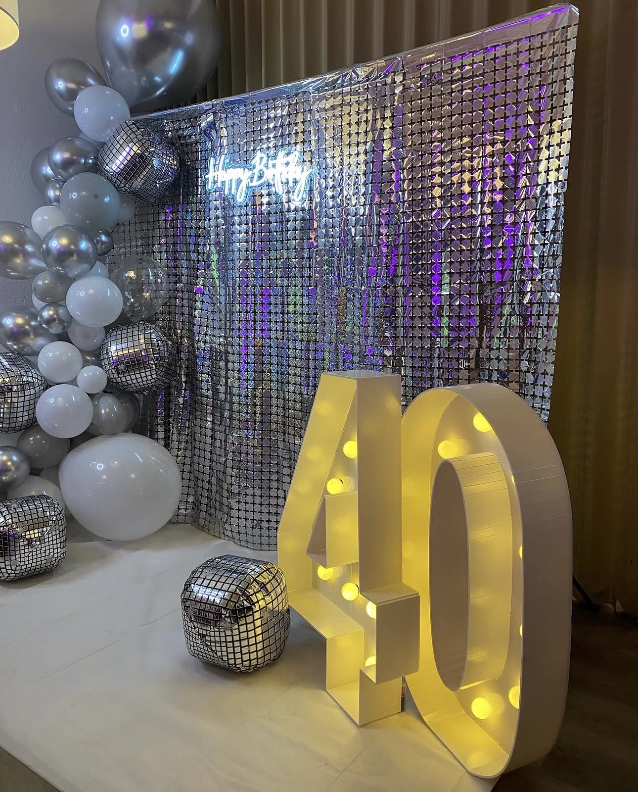 Silberne Pailettenwand mit XXL-Leuchtzahl 40 und Neon-Schriftzug
